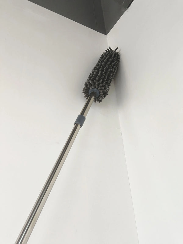 Telescopic Microfiber Removable Duster reaching high corner for effective dusting.