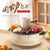 Portable Charcoal Grill & Outdoor Cooker with tea kettle, fruits, and cheese for versatile outdoor cooking.