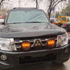 Round LED Strobe Warning Light 12V mounted on a black vehicle's front grille, enhancing visibility in low light.