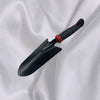Outdoor Gardening Hand Shovel resting on a white fabric background, featuring a compact and ergonomic design for gardening.