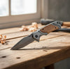 3D Pattern Blade Olive Wood Handle Pocket Knife displayed on a wooden surface, showcasing its elegant design.