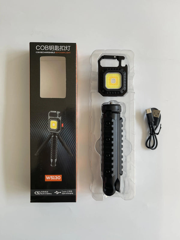 Portable COB LED Keychain Work Light with packaging, tripod, and USB charging cable displayed on a white background.
