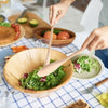 Nature Bamboo Wooden Coffee Milk Stir Spoon mixing salad in a large wooden bowl, eco-friendly kitchen utensil.