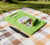 Mini Kitchen Chopping Board with Knife placed on a picnic blanket with a cucumber and a knife next to it.