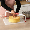 A person using the Big Cake Tierer to level a sponge cake on a countertop with baking tools in the background.
