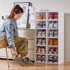 Woman organizing shoes using Clear Foldable Shoe Storage Rack 6 Tier for space-saving shoe storage.