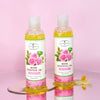 Pure Natural Rose Essential Oil bottles for hair and skin nourishment on a pink background.
