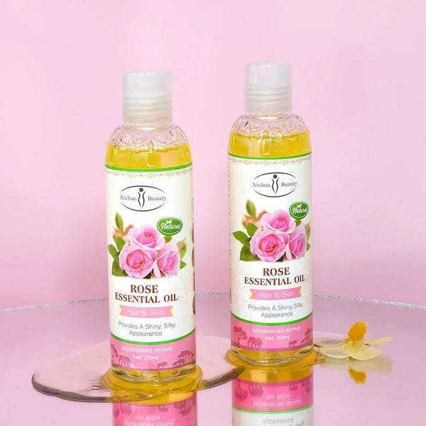 Pure Natural Rose Essential Oil bottles for hair and skin nourishment on a pink background.