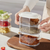Person organizing spices with the 3-Tier Stackable Spice and Snack Tower on a kitchen countertop.