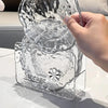 Hand holding the 6 Pc Flower-Shaped Snack Tray storage set showcasing petal-edged plates in a stylish storage container.