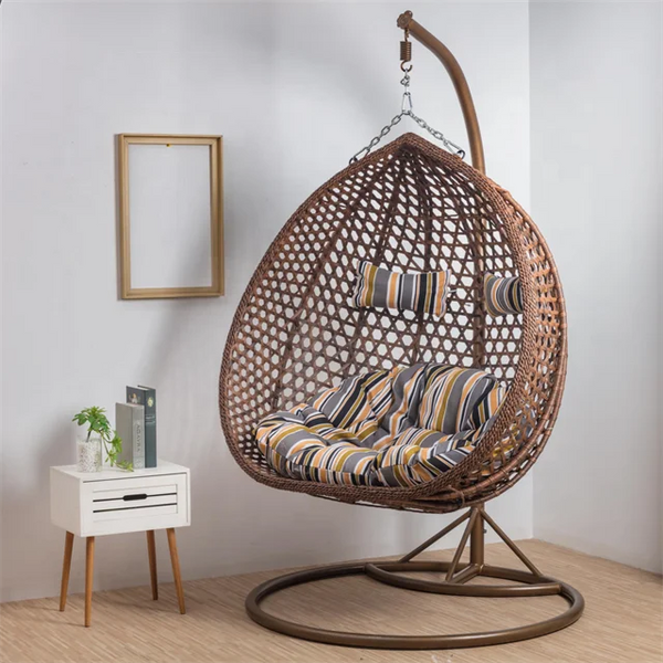 Top Quality Outdoor Magic Rattan Single Sofa Chair hanging in a stylish, modern indoor setting with cushions.