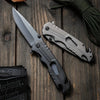 High Hardness Steel Folding Survival Pocket Knife resting on a wooden surface, showcasing its sleek design and dual-tone finish.