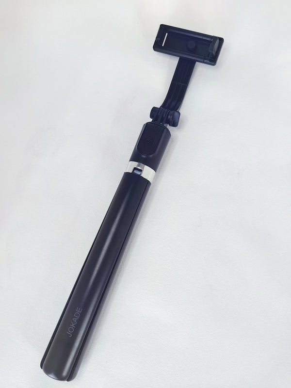 Wireless Selfie Stick for Smartphones lying flat on a white surface, ready for group photos and videos.