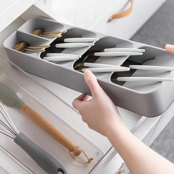 Compact Drawer Cutlery Spoons Knives Holder and Organizer in a kitchen drawer, neatly arranged utensils.