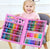 A happy child holding the open 208 Piece Deluxe Kids Art Sketching and Drawing Set showcasing colors and tools.