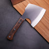 Handmade Forged Heavy Duty Cleaver on a wooden cutting board, showcasing its sharp blade and sturdy grip.