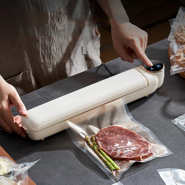 Portable Mini Food Vacuum Packing Organising Sealer in use, sealing food in vacuum bags on a kitchen counter.