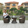 Woman enjoying a drink while relaxing in the Garden Lounge Wicker Furniture Set by a serene outdoor waterfront.