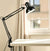 Flexible Adjustable Swing Arm Clip Desk Lamp positioned on desk, providing focused task lighting.
