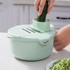 12-in-1 Manual Vegetable Chopper and Slicer in use with a cucumber being sliced into spiral shapes.