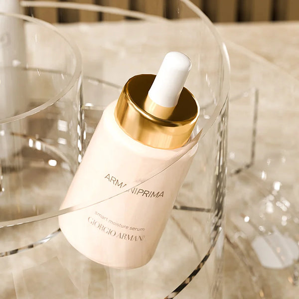 Giorgio Armani Armani Prima Smart Moisture Serum in transparent dropper bottle displayed in a clear makeup organizer.