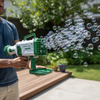 Light-Up Bubble Bazooka Machine Gun producing a stream of bubbles during outdoor playtime with a person holding it.
