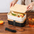 Lightweight Microwave-Safe Bento Lunch Box filled with pasta, vegetables on a wooden table with a drink.