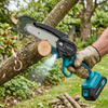 A user operates the 6-Inch Cordless Mini Lithium Electric Chainsaw to trim branches in a garden.