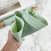 Non-Stick Silicone Rolling Pin & Pastry Mat Baking Set with a flexible mint green pastry mat held in hand.