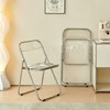 Modern Transparent Folding Chair displayed in a stylish interior with a light fixture and a neatly arranged side table.