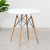 75cm Modern Eames Design Round Dining Table with white top and wooden legs in a modern setting.