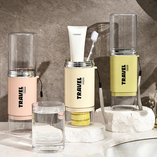 Plastic Travel Toothbrush Cup Portable Couple Set displayed on a countertop with toothbrushes and toothpaste.