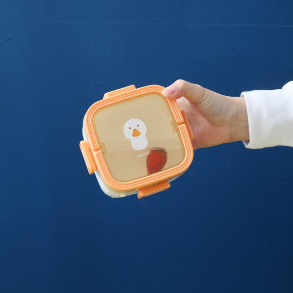 Portable 800ml Kids Bento Lunch Box with Handle being held, featuring a cute duck design, ideal for school lunches.