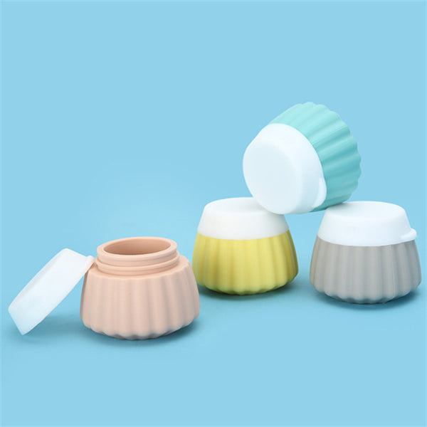 Portable travel silicone bottle set featuring four colorful, ribbed bottles on a blue background.