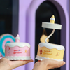Portable LED Cake Desk Lamp displayed in hands, featuring playful birthday designs and warm glow.
