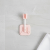 Round Swivel Shower Head Holder Bracket mounted on a smooth surface in a soft pink color.