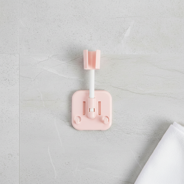 Round Swivel Shower Head Holder Bracket mounted on a smooth surface in a soft pink color.