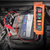 12V-24V Car Battery Diagnostic Tool attached to a car battery, showing charging status and battery health indicators.