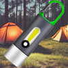 Portable Waterproof COB LED Rechargeable Keychain Light in front of camping tents.