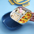 Stainless Steel Divided Lunch Box with fruits and snacks in divided compartments for organized meals.