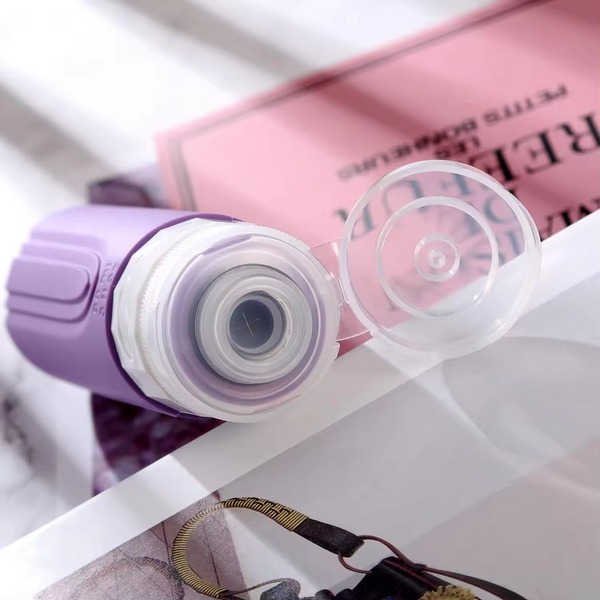 Travel Silicone Lotion Bottles in purple with open cap on a magazine, perfect for travel and leak-proof storage.