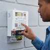 Person using a Single Phase Prepaid Electricity Sub Meter to manage power consumption.
