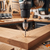 Keyless Drill Chuck Adapter in use with a power drill, drilling into a piece of wood in a workshop.