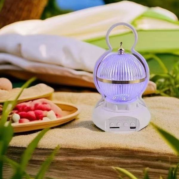 Rechargeable LED Camping Lamp with Bluetooth Speaker displayed on a grassy surface, showcasing its compact and stylish design.
