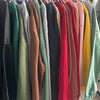 Colorful display of custom printing men tie dye sweatshirts hanging on a rack, showcasing various vibrant shades.