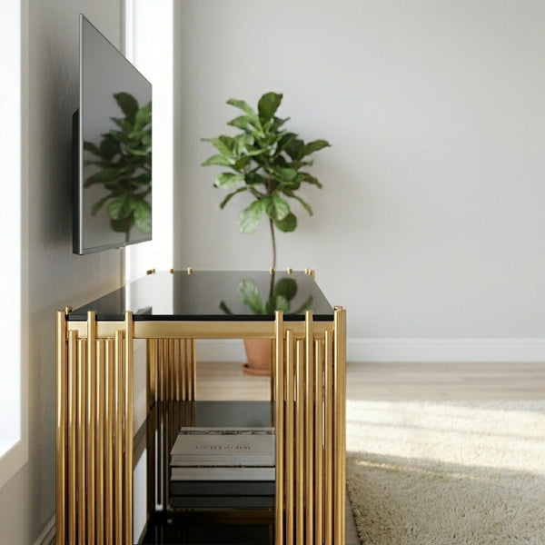 Gold Frame TV Stand with Black Glass Shelves in a modern living room setting with a plant and TV.