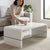 A woman placing a coffee cup on the Arch High Gloss Coffee Table White in a modern living room setting.