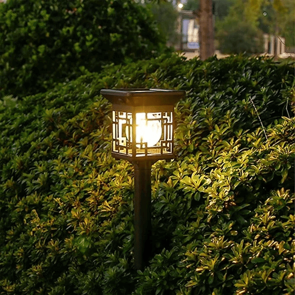 Illuminated 2-Pack Solar Garden Lights featured in a garden setting, enhancing outdoor ambiance at night.