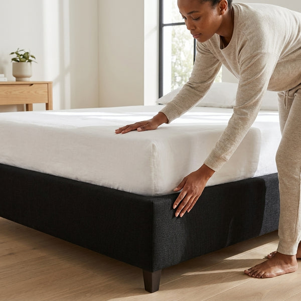Person adjusting mattress on a 1.8M Heavy-Duty Bed Base in a modern bedroom setting.