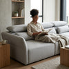 A woman reading on the SF-622B Modular Fabric Couch with adjustable headrests in a modern living room.